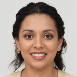 Joyful latino young-adult female with medium  brown hair and brown eyes