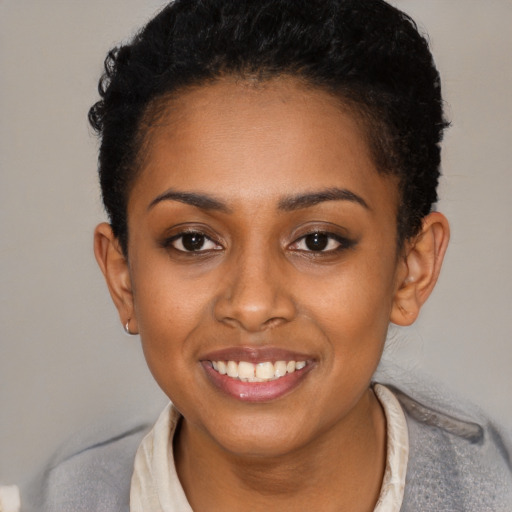 Joyful black young-adult female with short  brown hair and brown eyes