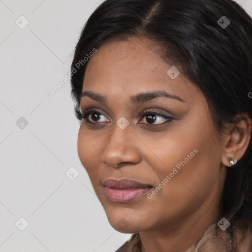 Joyful black young-adult female with long  black hair and brown eyes