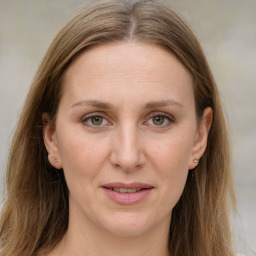 Joyful white adult female with long  brown hair and grey eyes