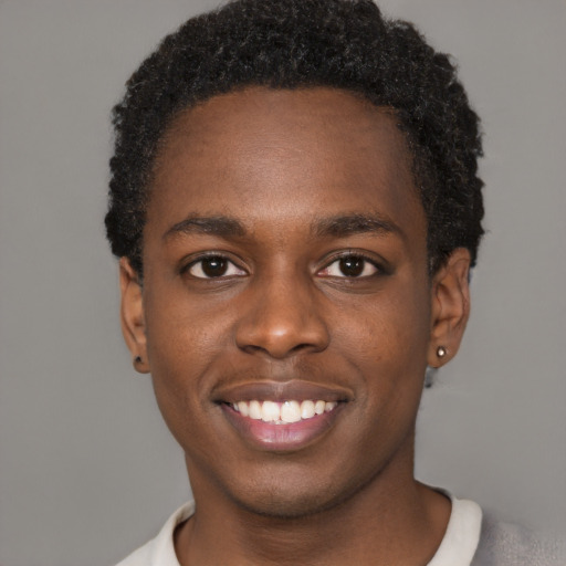 Joyful black young-adult male with short  black hair and brown eyes