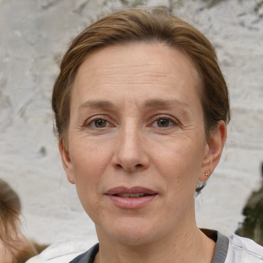 Joyful white adult female with medium  brown hair and grey eyes