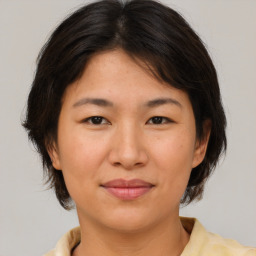 Joyful asian young-adult female with medium  brown hair and brown eyes