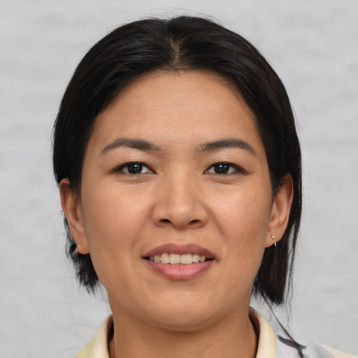 Joyful asian adult female with medium  brown hair and brown eyes