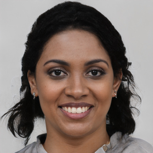 Joyful black young-adult female with medium  black hair and brown eyes