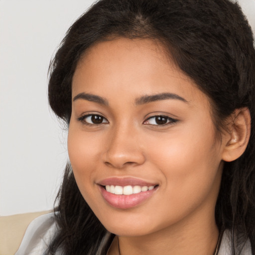 Joyful latino young-adult female with long  brown hair and brown eyes