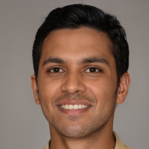 Joyful latino young-adult male with short  black hair and brown eyes