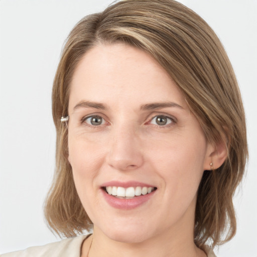 Joyful white young-adult female with medium  brown hair and grey eyes