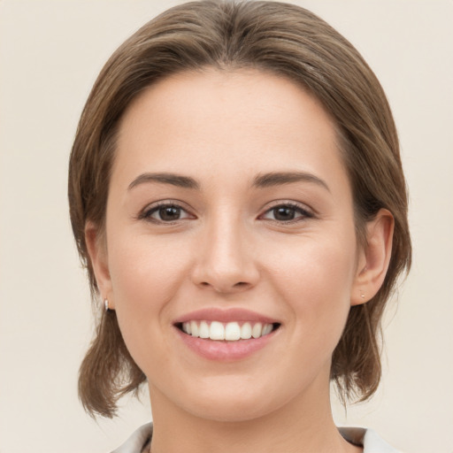 Joyful white young-adult female with medium  brown hair and green eyes