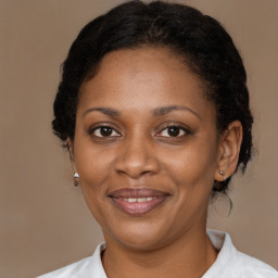 Joyful black adult female with medium  brown hair and brown eyes