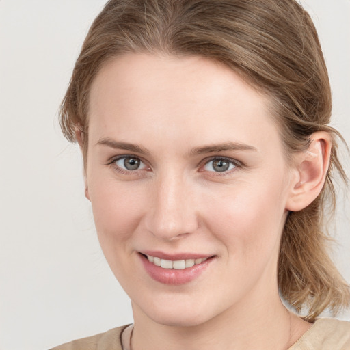 Joyful white young-adult female with medium  brown hair and grey eyes