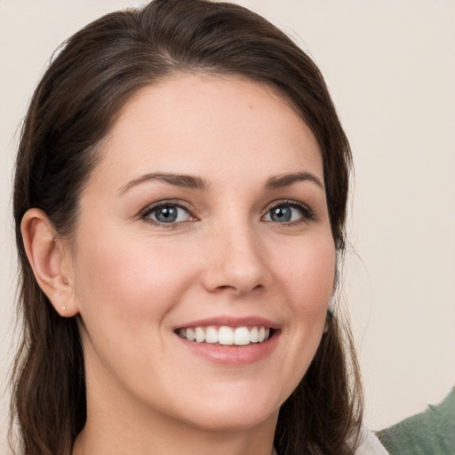 Joyful white young-adult female with long  brown hair and grey eyes