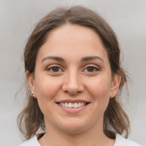 Joyful white young-adult female with medium  brown hair and grey eyes