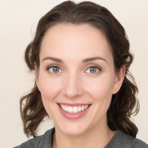 Joyful white young-adult female with medium  brown hair and blue eyes