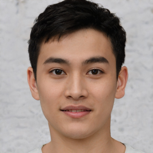 Joyful asian young-adult male with short  brown hair and brown eyes