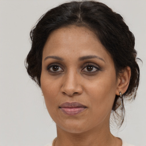 Joyful black adult female with medium  brown hair and brown eyes