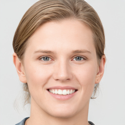 Joyful white young-adult female with medium  brown hair and blue eyes