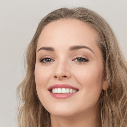 Joyful white young-adult female with long  brown hair and green eyes