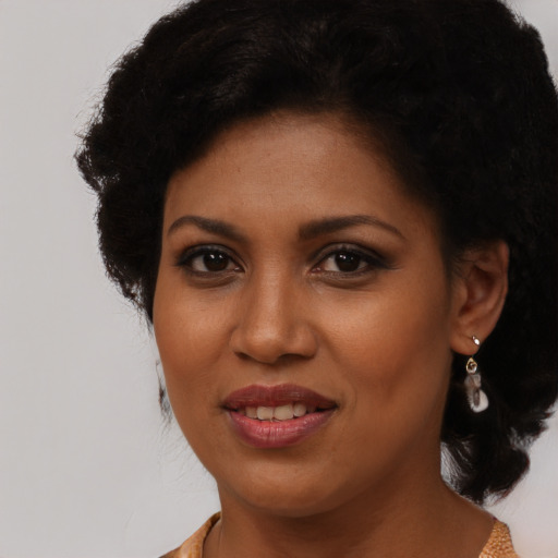 Joyful black young-adult female with long  brown hair and brown eyes