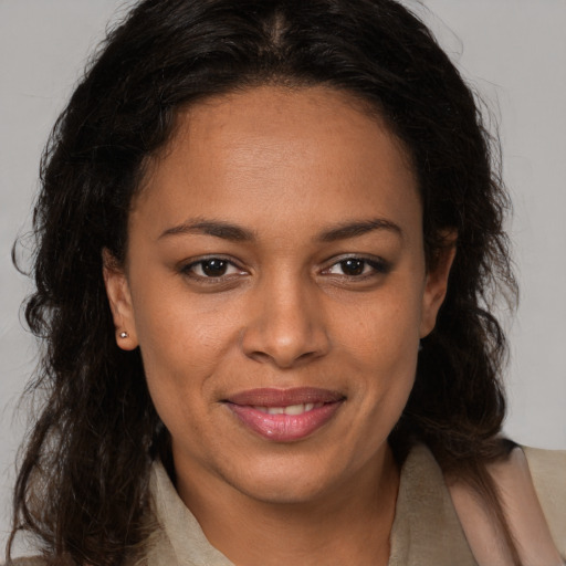 Joyful black young-adult female with long  brown hair and brown eyes