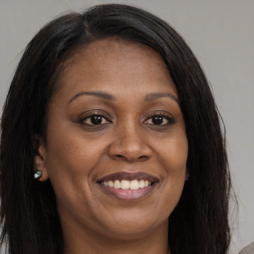 Joyful black young-adult female with long  brown hair and brown eyes