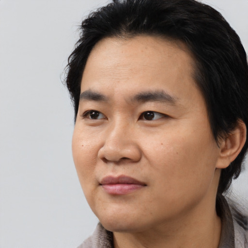 Joyful asian young-adult male with medium  black hair and brown eyes