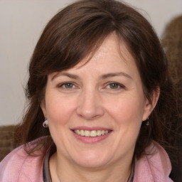 Joyful white adult female with medium  brown hair and grey eyes