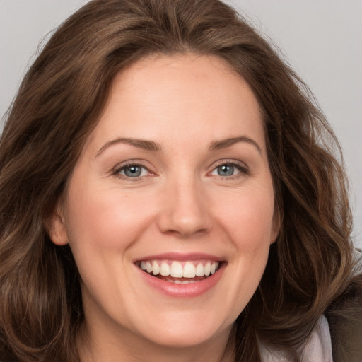 Joyful white young-adult female with long  brown hair and grey eyes