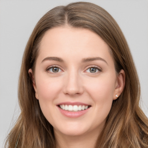 Joyful white young-adult female with long  brown hair and grey eyes