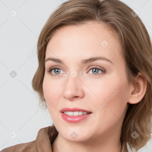 Joyful white young-adult female with medium  brown hair and blue eyes