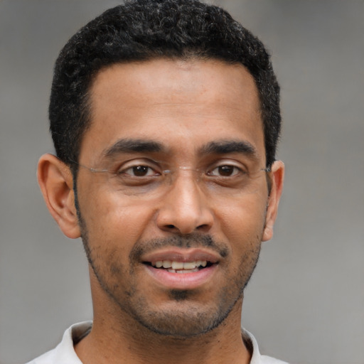 Joyful black young-adult male with short  black hair and brown eyes