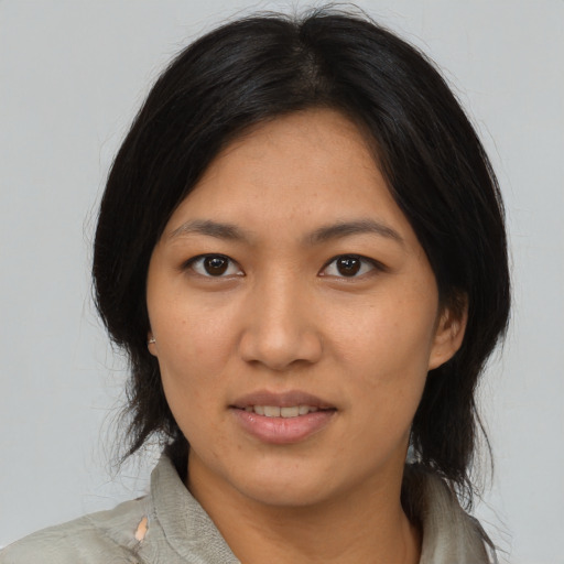 Joyful latino adult female with medium  black hair and brown eyes