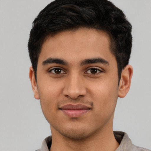 Joyful latino young-adult male with short  brown hair and brown eyes