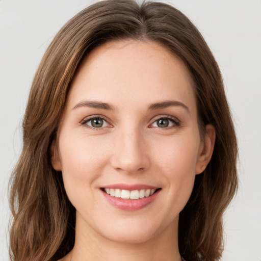 Joyful white young-adult female with long  brown hair and green eyes