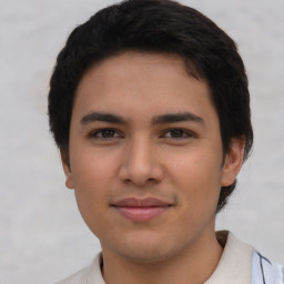 Joyful latino young-adult male with short  brown hair and brown eyes