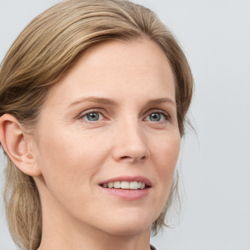 Joyful white adult female with medium  brown hair and green eyes