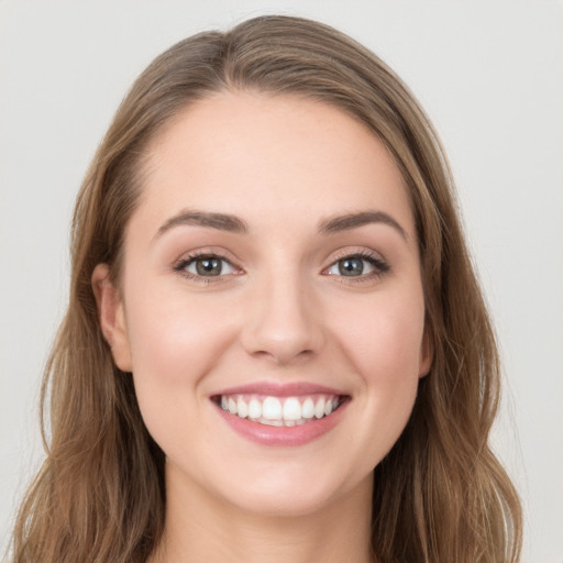 Joyful white young-adult female with long  brown hair and grey eyes