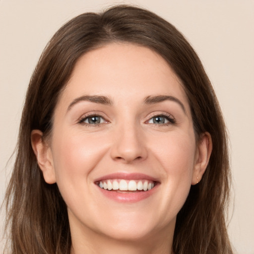 Joyful white young-adult female with long  brown hair and grey eyes