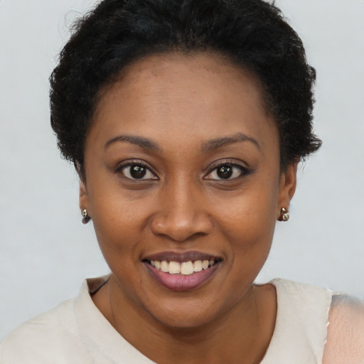 Joyful black young-adult female with short  brown hair and brown eyes