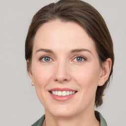 Joyful white young-adult female with medium  brown hair and green eyes