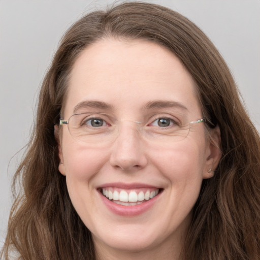 Joyful white adult female with long  brown hair and grey eyes