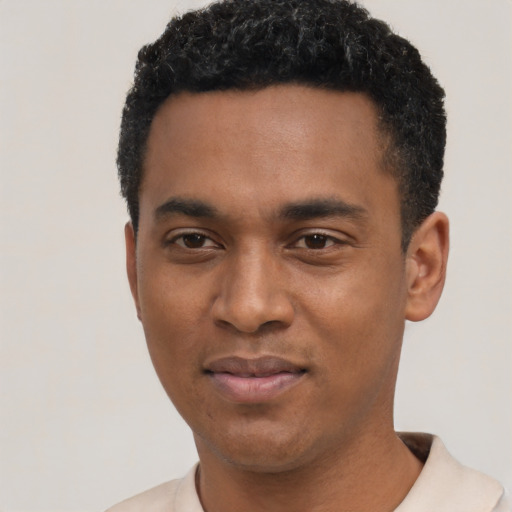 Joyful black young-adult male with short  black hair and brown eyes