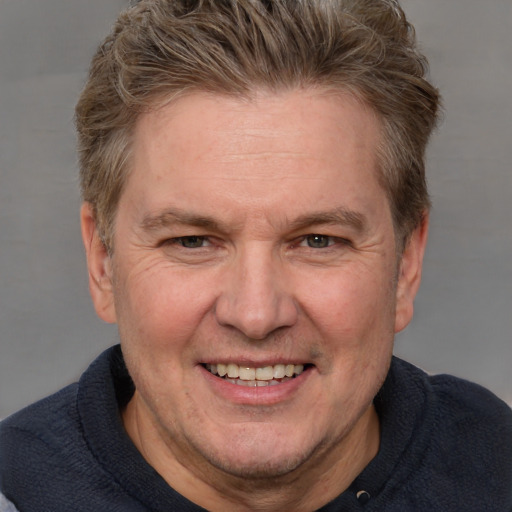 Joyful white adult male with short  brown hair and blue eyes