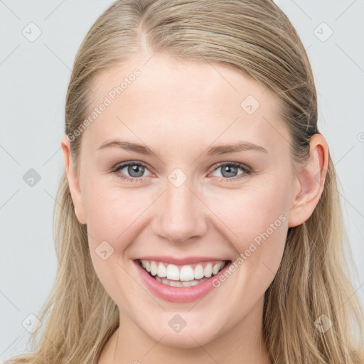 Joyful white young-adult female with long  brown hair and blue eyes