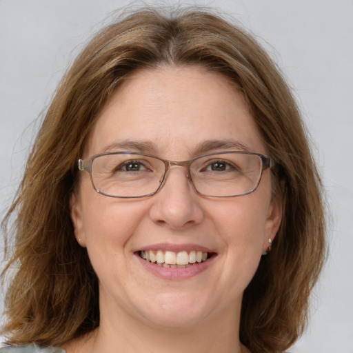 Joyful white adult female with long  brown hair and green eyes