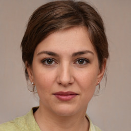 Joyful white young-adult female with medium  brown hair and grey eyes