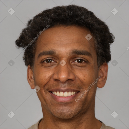 Joyful black adult male with short  brown hair and brown eyes