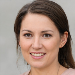 Joyful white young-adult female with medium  brown hair and grey eyes