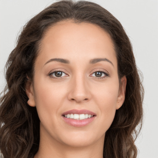 Joyful white young-adult female with long  brown hair and brown eyes