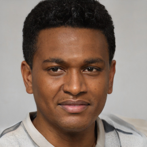 Joyful black young-adult male with short  brown hair and brown eyes